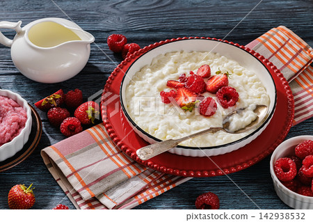 Rice porridge in a bowl topped with berries Rice porridge in a bowl topped with berries 142938532