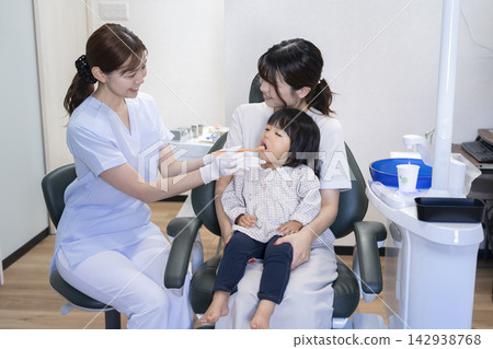 一名2歲女童和她的母親在牙科診所接受刷牙指導。 一名2歲女童和她的母親在牙科診所接受刷牙指導。 142938768