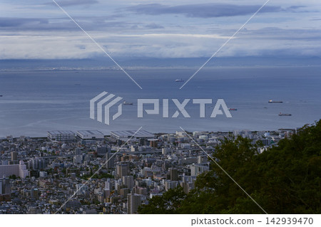 A view of Kobe's cityscape and harbor from a hilltop. A view of Kobe's cityscape and harbor from a hilltop. 142939470