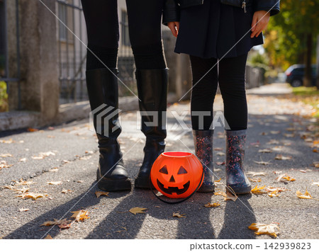 Mother and daughter enjoying Halloween trick or treat in neighborhood Mother and daughter enjoying Halloween trick or treat in neighborhood 142939823