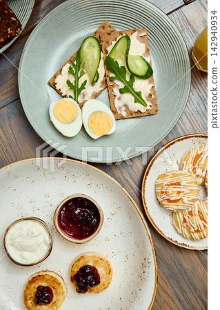 Breakfast Table with Syrniki, Fried Eggs, Toasts and Beverages Breakfast Table with Syrniki, Fried Eggs, Toasts and Beverages 142940934