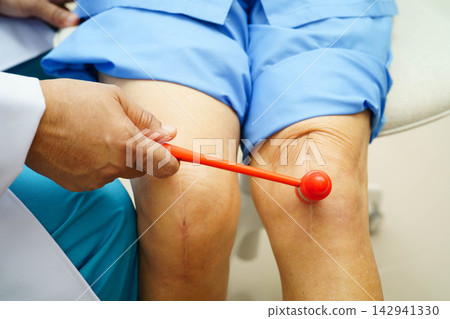 Asian doctor knock on knee reflex nerve for check and treatment senior patient in hospital. Asian doctor knock on knee reflex nerve for check and treatment senior patient in hospital. 142941330
