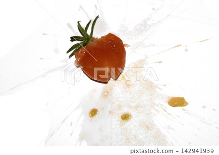 A squashed splattered and crushed broken fresh tomato with seeds 142941939