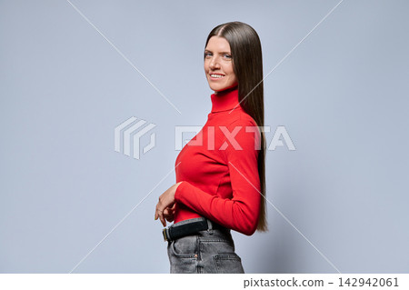 Young woman smiling in half turn profile view on light background Young woman smiling in half turn profile view on light background 142942061