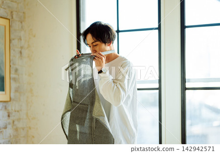 一個男人脖子上圍著圍裙,準備做些什麼。 一個男人脖子上圍著圍裙,準備做些什麼。 142942571