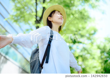 一位背著背包、戴著帽子的女子,張開雙臂,走在綠意盎然的草地上,看起來神清氣爽。 一位背著背包、戴著帽子的女子,張開雙臂,走在綠意盎然的草地上,看起來神清氣爽。 142942650