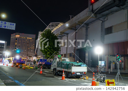 車站門前的道路上夜間有建築施工和工程車輛。 車站門前的道路上夜間有建築施工和工程車輛。 142942756