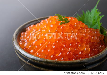 A close-up of a rice bowl topped with plenty of fresh salmon roe. A close-up of a rice bowl topped with plenty of fresh salmon roe. 142943247