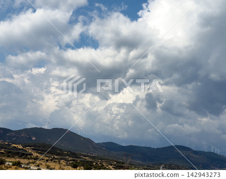 Dramatic cloudy sky above distant rugged mountain landscape 142943273