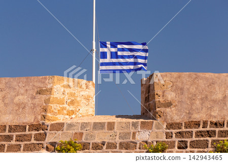 Greek National Flag Flying Above Stone Harbor Wall in Chania, Crete, Greece Greek National Flag Flying Above Stone Harbor Wall in Chania, Crete, Greece 142943465