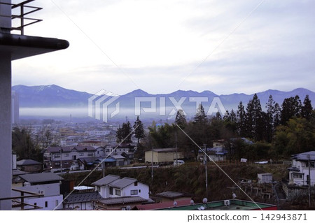 Low clouds hang over the city of Kaminoyama and the surrounding mountains in winter. Low clouds hang over the city of Kaminoyama and the surrounding mountains in winter. 142943871