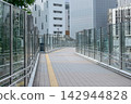 A glass-walled pedestrian bridge connecting office districts – a landscape of a well-maintained urban environment. 142944828