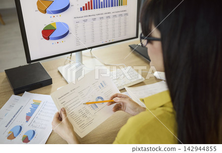 Woman analyst reviewing finance charts on computer, accounting data and forecast Woman analyst reviewing finance charts on computer, accounting data and forecast 142944855