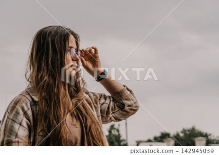 Woman glasses portrait adjusting eyewear against a cloudy sky with copy space for text Woman glasses portrait adjusting eyewear against a cloudy sky with copy space for text 142945039