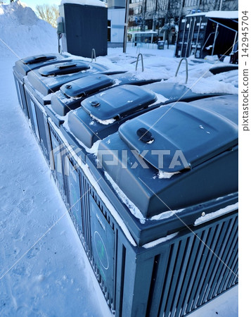Modern outdoor trash containers in the city, covered in snow. Modern outdoor trash containers in the city, covered in snow. 142945704