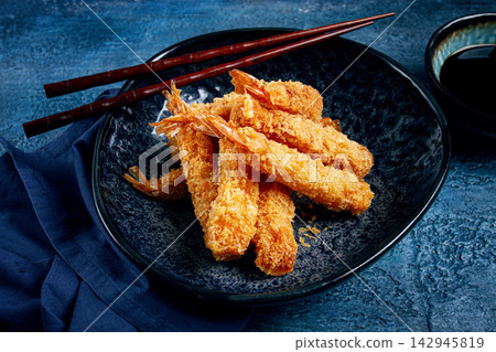 shrimp in tempura, deep fried, on a black plate, with soy sauce, close-up, top view, no people, 142945819