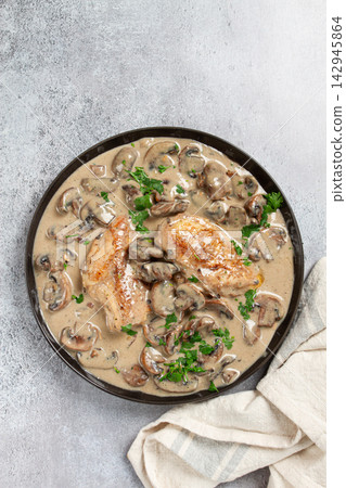 chicken in cream sauce with mushrooms, on a black plate, no people chicken in cream sauce with mushrooms, on a black plate, no people 142945864