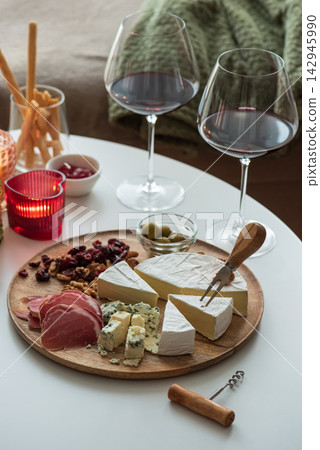 Gourmet cheese and charcuterie board with red wine and artisanal accompaniments beautifully arranged Gourmet cheese and charcuterie board with red wine and artisanal accompaniments beautifully arranged 142945990