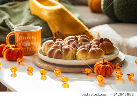 Cozy Autumn Scene Featuring Pumpkin Shaped Buns and Decorative Lights Cozy Autumn Scene Featuring Pumpkin Shaped Buns and Decorative Lights 142945998