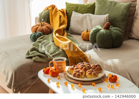 Cozy Autumn Scene with Pumpkins Tea and Breads on a Sofa Cozy Autumn Scene with Pumpkins Tea and Breads on a Sofa 142946000