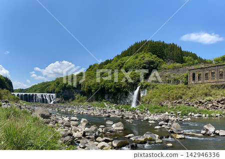 The lush greenery of the Shinda Waterfall and the ruins of a power plant The lush greenery of the Shinda Waterfall and the ruins of a power plant 142946336