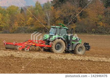 tractor plowing a field tractor plowing a field 142946476