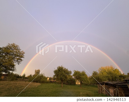 Vibrant double rainbow arching over a rural countryside landscape at sunset Vibrant double rainbow arching over a rural countryside landscape at sunset 142946513
