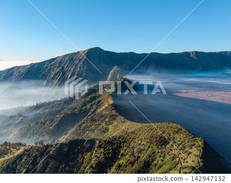 Mist curls around volcanic slopes Mist curls around volcanic slopes 142947132