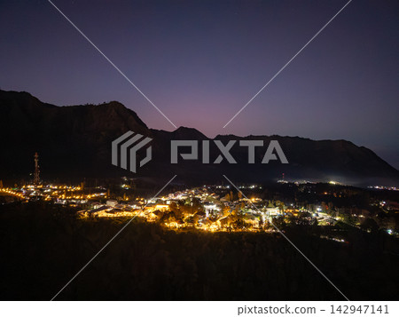 Night sky glows soft purple above mountain peaks 142947141
