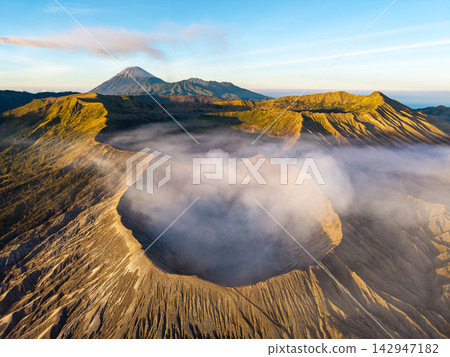 Majestic volcano rises above misty dawn glow Majestic volcano rises above misty dawn glow 142947182