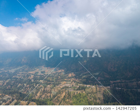 Breathtaking mountain range rises grandly beneath cloud Breathtaking mountain range rises grandly beneath cloud 142947205