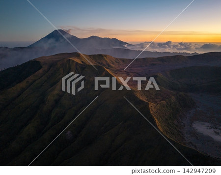 Misty peaks glow under dawn soft light 142947209