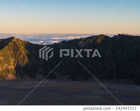 Sunlight glows over jagged mountain peaks Sunlight glows over jagged mountain peaks 142947211