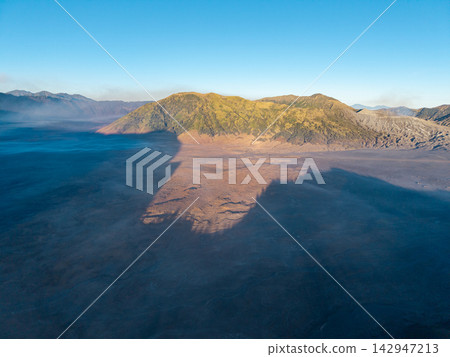 Majestic mountain casts long shadow over vast, misty valley Majestic mountain casts long shadow over vast, misty valley 142947213