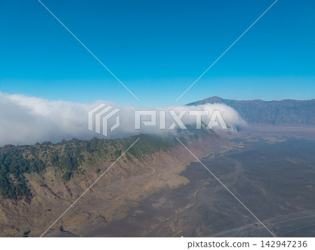 Mountain valley surrounded by mist and forest at Bromo Mountain valley surrounded by mist and forest at Bromo 142947236