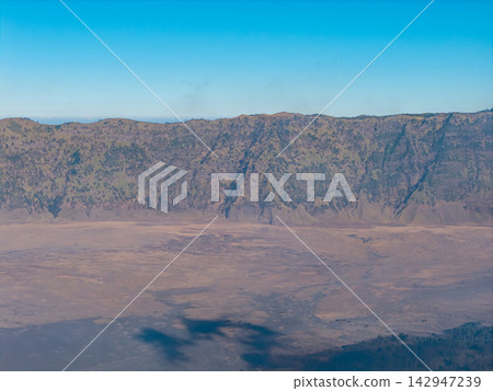 Massive volcanic caldera stretches beneath a clear blue sky Massive volcanic caldera stretches beneath a clear blue sky 142947239
