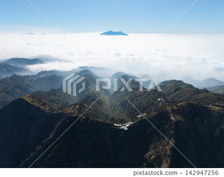Majestic mountains pierce cloud sea below Majestic mountains pierce cloud sea below 142947256