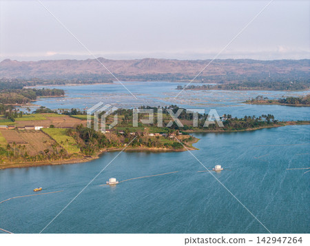 Vast lake stretches under soft, hazy sky Vast lake stretches under soft, hazy sky 142947264