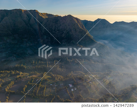 Misty dawn blankets rugged mountain ridges 142947289