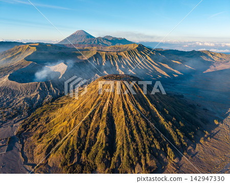 Golden light bathes volcanic slopes Golden light bathes volcanic slopes 142947330