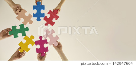 Hands Arranging Colorful Jigsaw Pieces for Collaboration and Shared Solutions Hands Arranging Colorful Jigsaw Pieces for Collaboration and Shared Solutions 142947604