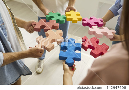 Coworkers Connecting Colorful Puzzle Pieces for Teamwork and Team Strategy Coworkers Connecting Colorful Puzzle Pieces for Teamwork and Team Strategy 142947606