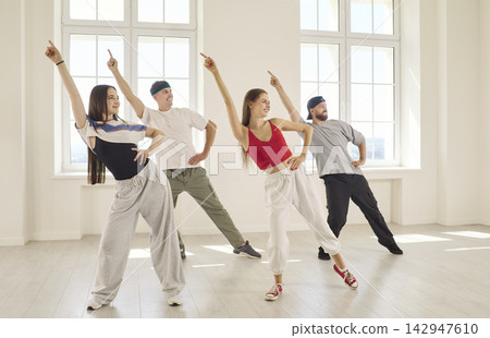 Four Friends Performing Energetic Group Dance Routine Together in Bright Studio Four Friends Performing Energetic Group Dance Routine Together in Bright Studio 142947610