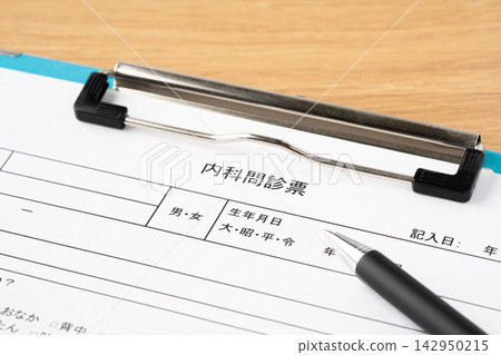 一份醫療問捲和一支原子筆夾在寫字板上。 142950215
