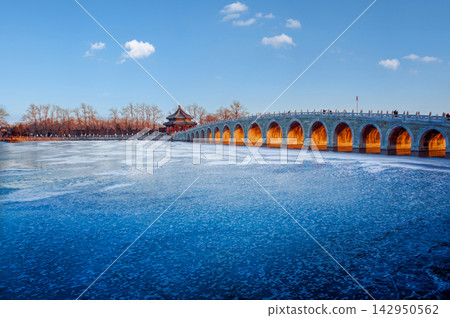 The Seventeen Arch Bridge over the frozen Kunming Lake at the Summer Palace in Beijing, China under a clear blue sky The Seventeen Arch Bridge over the frozen Kunming Lake at the Summer Palace in Beijing, China under a clear blue sky 142950562