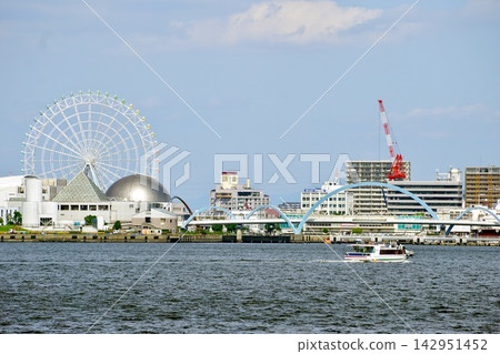 A view of Nagoya Port from Megras Garden Nagoya, including the large Ferris wheel and water buses traversing the bay. A view of Nagoya Port from Megras Garden Nagoya, including the large Ferris wheel and water buses traversing the bay. 142951452