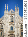 The beautiful facade and spire of Milan Cathedral stand out against the blue sky. 142951601