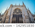 The beautiful back and spire of Milan Cathedral soaring against the blue sky. 142951830