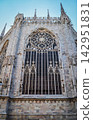 The beautiful back and spire of Milan Cathedral soaring against the blue sky. 142951831