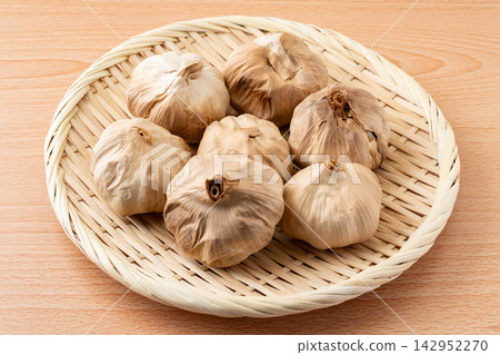 Aged black garlic served in a bamboo basket Aged black garlic served in a bamboo basket 142952270
